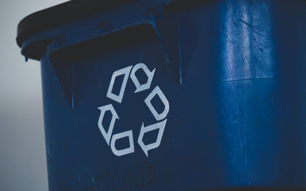 Close up of a blue recycling bin with white recycle logo