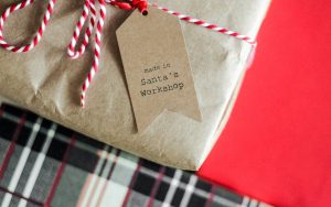 Christmas gift wrapped in brown paper with white and red string
