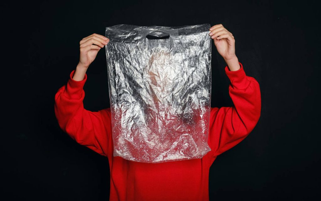 clear polythene bag held up by a person wearing a red jumper
