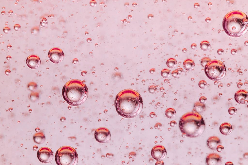 Bubbles suspended in pinkish liquid