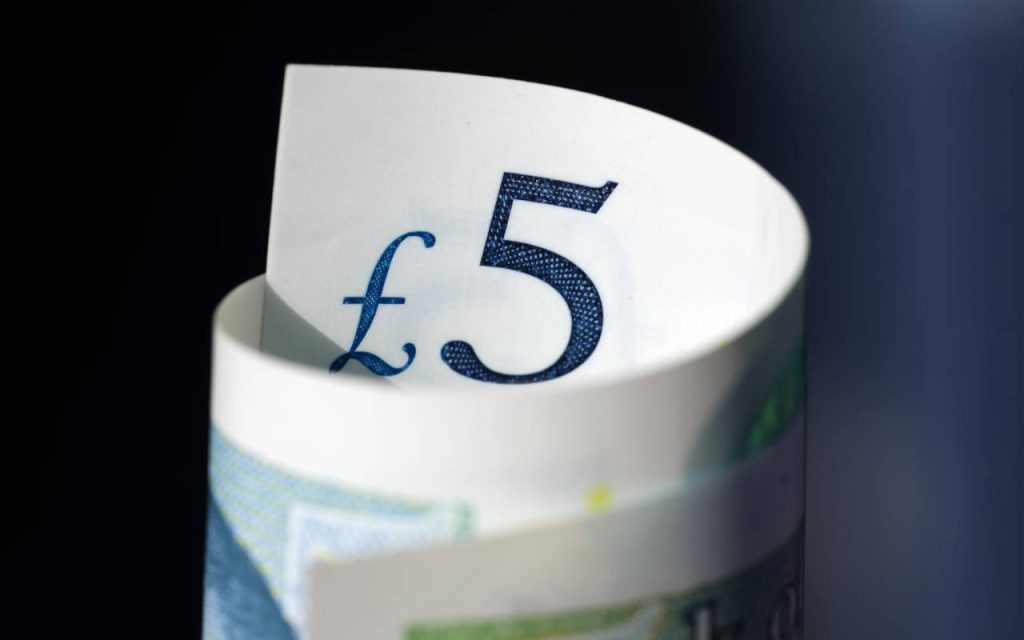Closeup photo of a rolled up five pound note