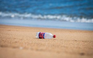 A plastic Dr Pepper bottle on a beach