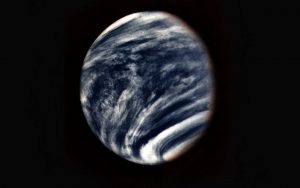 Vintage false-colour image of the planet Venus, from NASA archive. The planet appears dark blue, with white bands of cloud. Almost Earth-like. It is suspended in the blackness of space, with a fuzzy edge along the terminator.