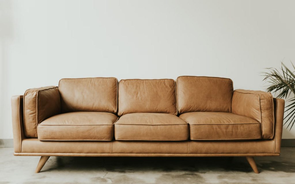 A beautiful brown leather sofa against a white wall.
