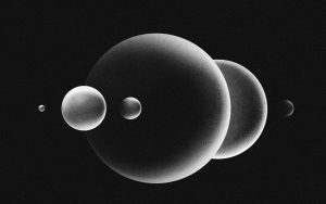 Representation of atoms. Black and white image of spheres of different shades of grey on a black background, high contrast