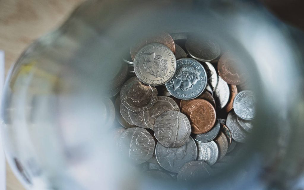 English money, close up. A mixture of coins in a jar, shot from above. Used to demonstrate tax, specifically the plastic packaging tax, and whether it has been effective or a failure