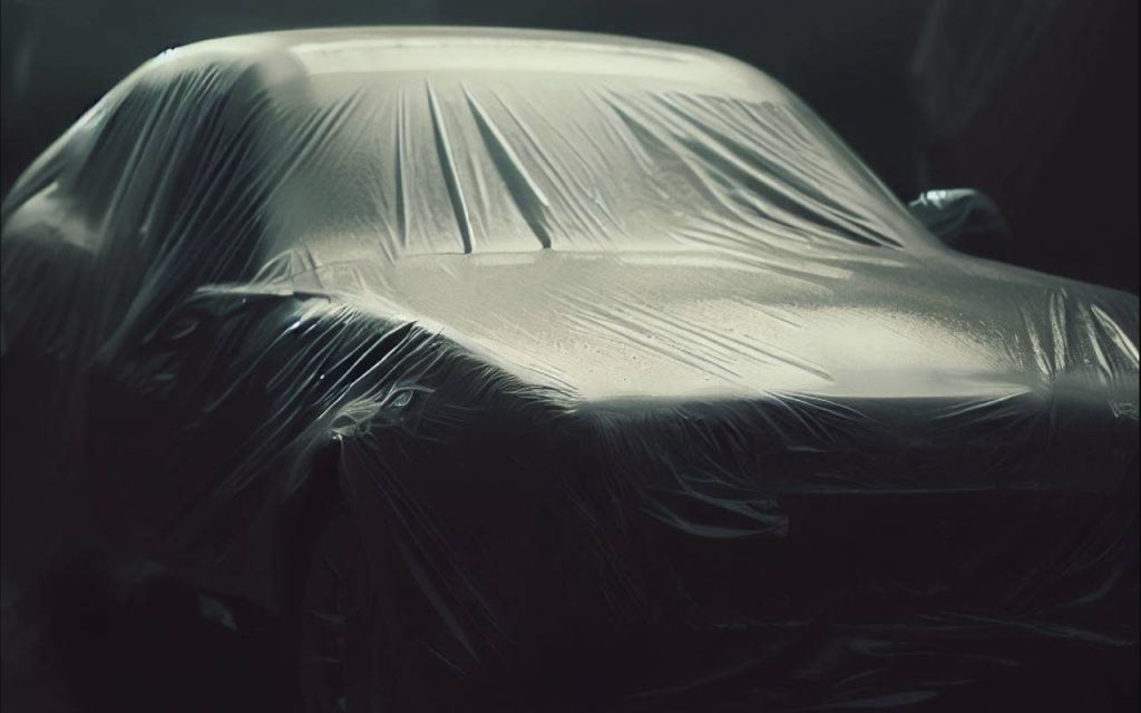 Shallow depth of field photo of a car wrapped in a huge polythene sheet. Demonstrating continuous polythene sheeting made by welding polythene. Heat sealable polythene can be welded into large, seamless sections for applications like car covers, farming and construction.
