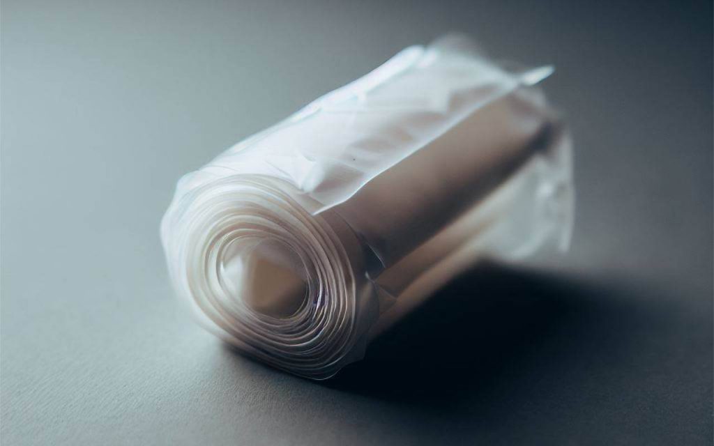 Close up shot of clear, small polythene bags on a roll, on a neutral background