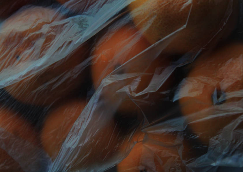 Close up shot of oranges in polythene wrapping. Low light, high contrast image