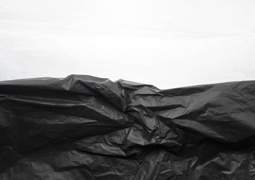 Black polythene bag closeup on a white background