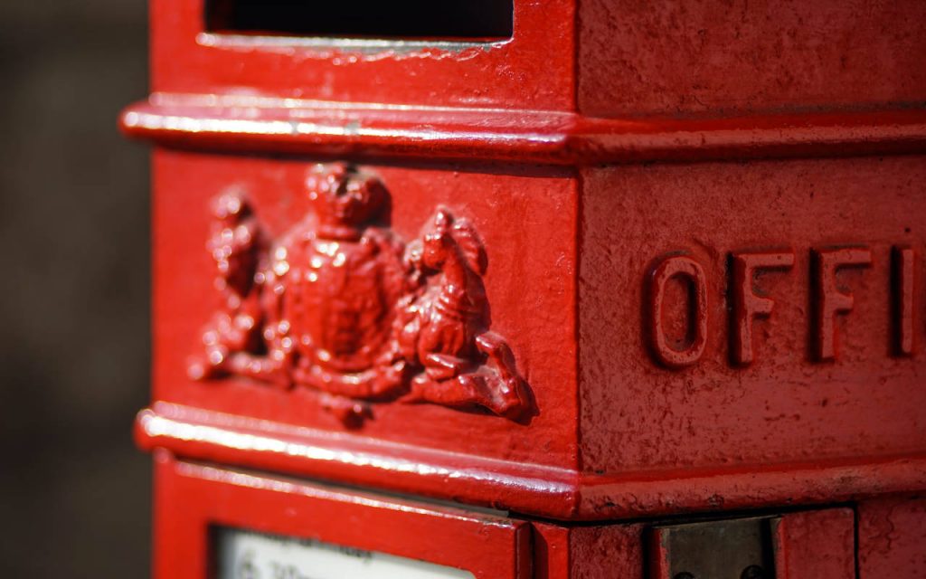 Extreme closeup of a red postbox in daylight