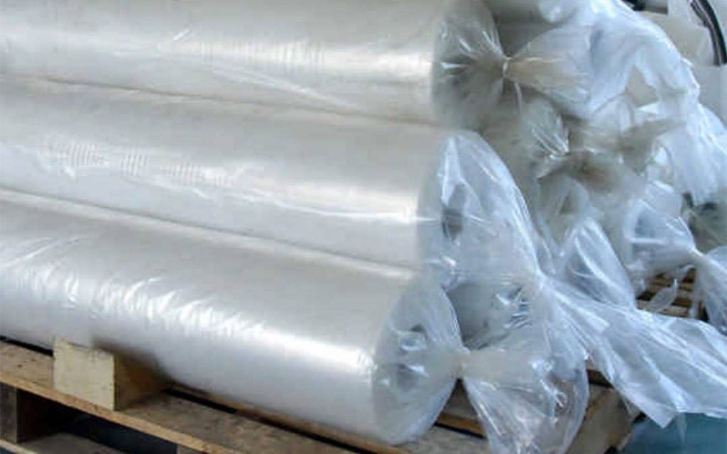 A pallet loaded with folded polythene rolls, wrapped in polythene bags for protection