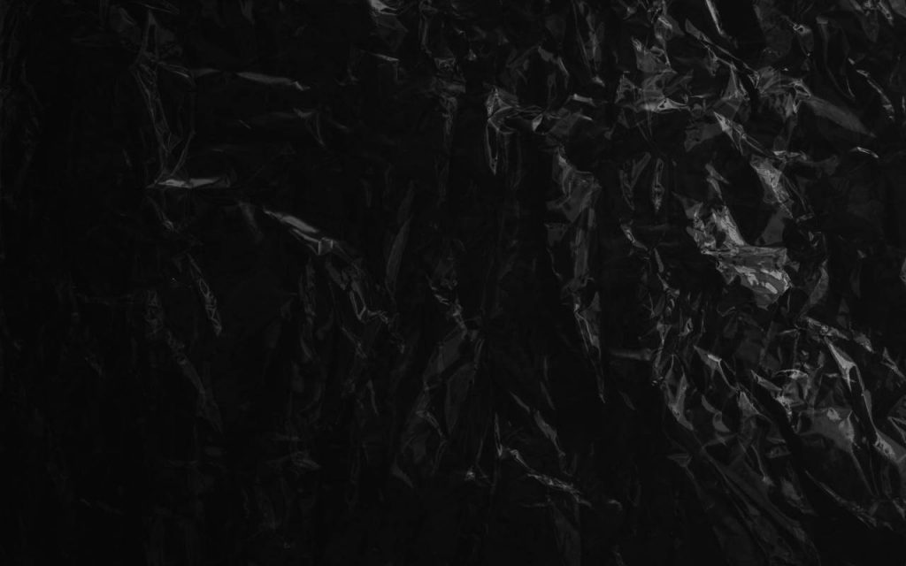 Photo of opaque black polythene sheet from above. Crinkles and reflections can be seen, but very few other features – the image is mostly black.jpg